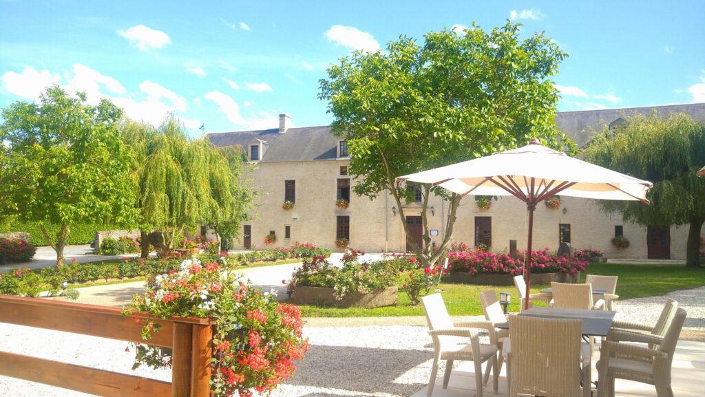 Mathan Manoir Garden en Crépon, destacando un entorno tranquilo con flores y un ambiente acogedor.