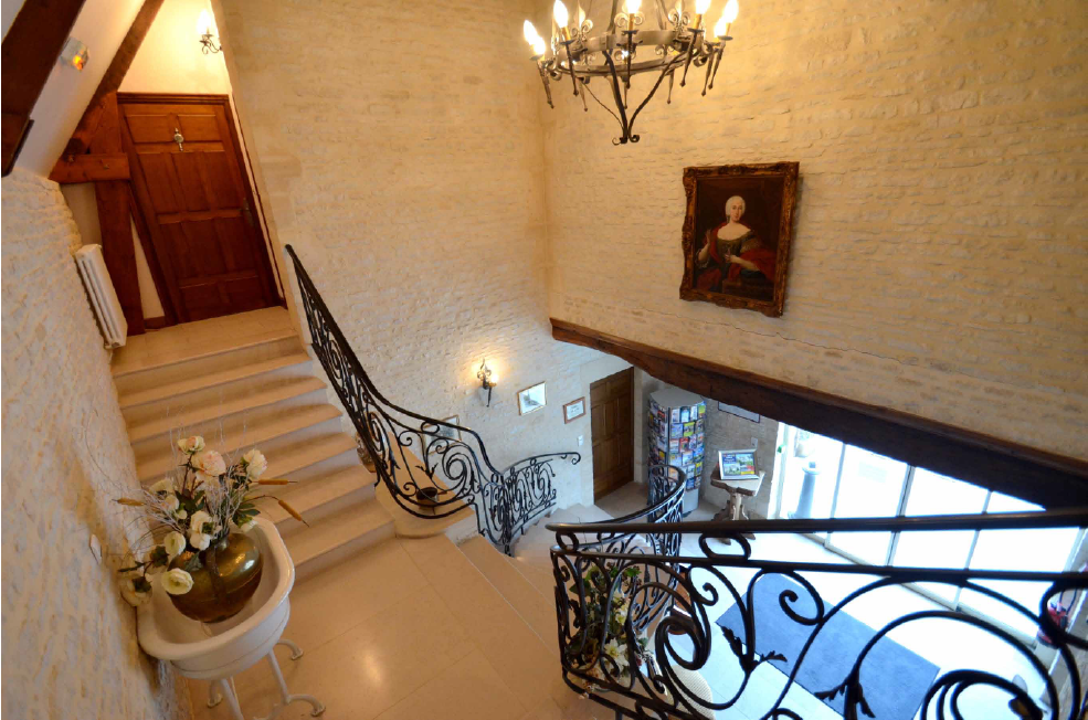 Elegante Treppe des Mathan -Herrenhauses mit einer raffinierten Dekoration und einer einladenden Beleuchtung, die historischen Charme und Moderne kombiniert.