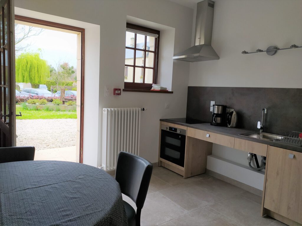 Cucina moderna e luminosa, con tavolo da pranzo, vista del Mathan Manor Park.