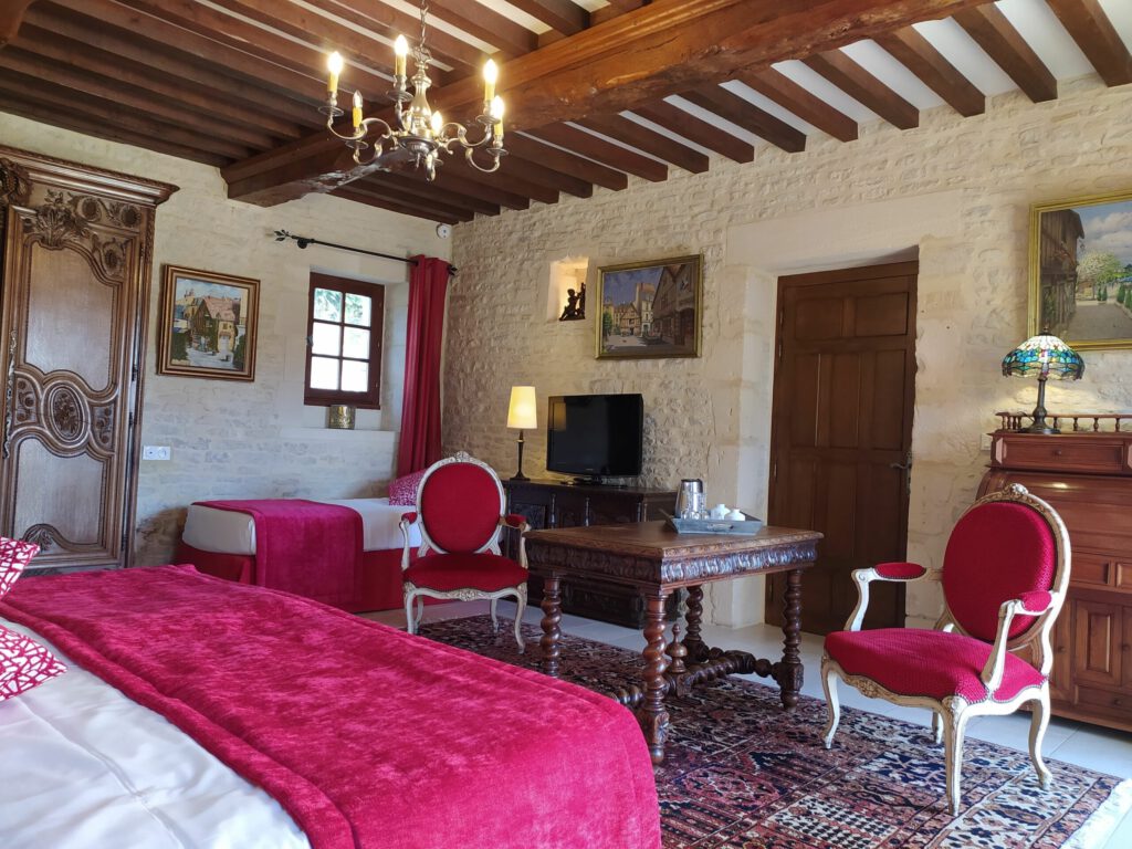 Junior Suite Triple PMR a Mathan Manor, con decorazione elegante, comfort moderno e atmosfera calda.