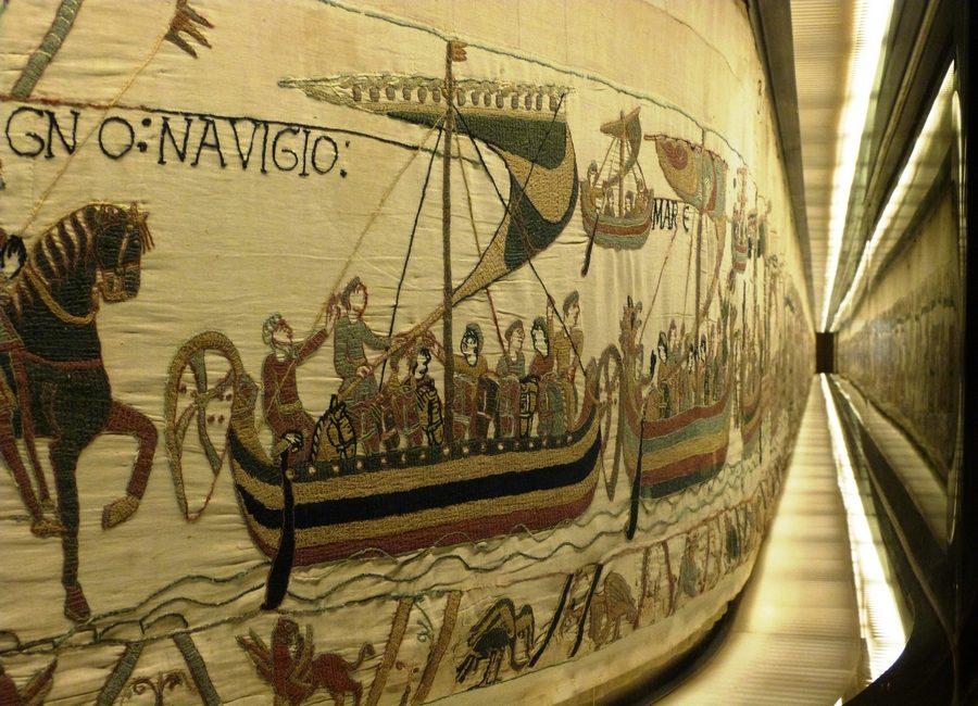 Arazzo che illustra i vasi vikingal e le figure storiche, esposte in un museo normanna.
