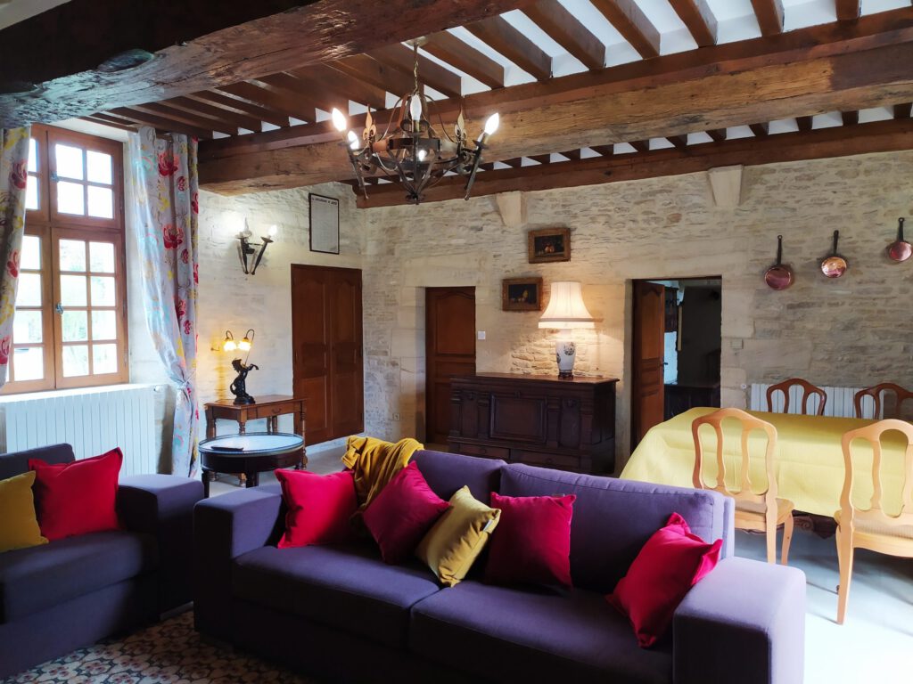 Elegante interno di un appartamento di prestigio a Mathan Manor, con divano e tavolo da pranzo, arredamento caldo e luminoso.