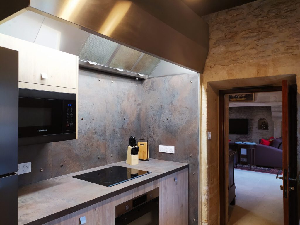 Cucina moderna ed elegante in un appartamento di prestigio a Mathan Manor, con una vista di un soggiorno caldo.