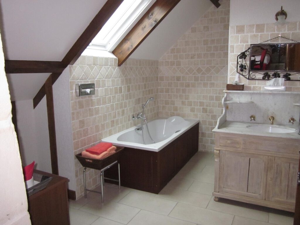 Bagno della suite junior, con vasca, lavello di marmo e decorazione in pietra, a Mathan Manor.