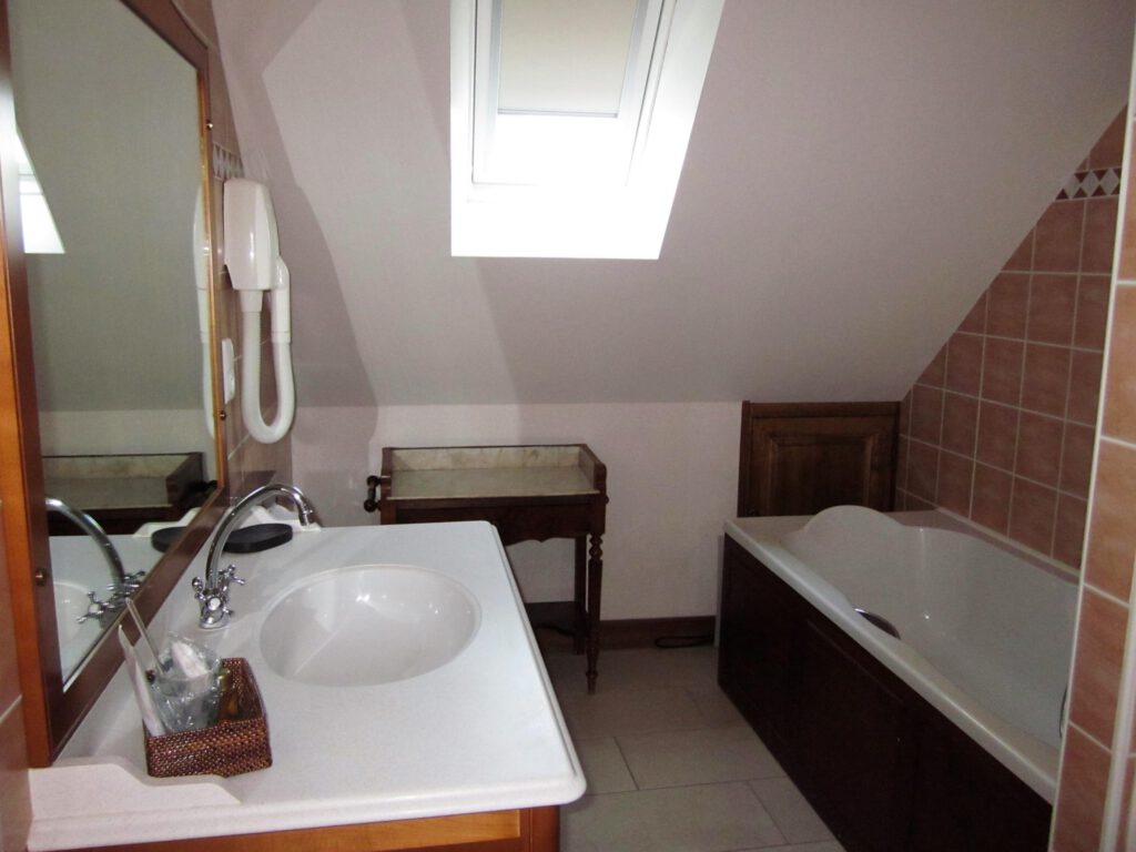 Bagno di un junior che segue Mathan Manor, con vasca, lavandino e arredamento caldo.
