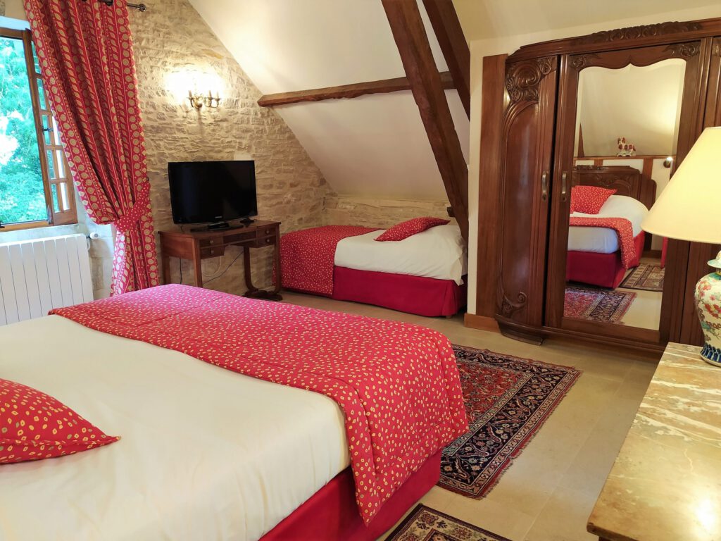 Elegante sala junior con due letti, arredamento caldo e TV, situato in un ambiente storico a Mathan Manor.