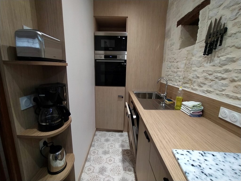 Cocina moderna y equipado en la suite junior de Mathan Manor, con encimera de madera y electrodomésticos.