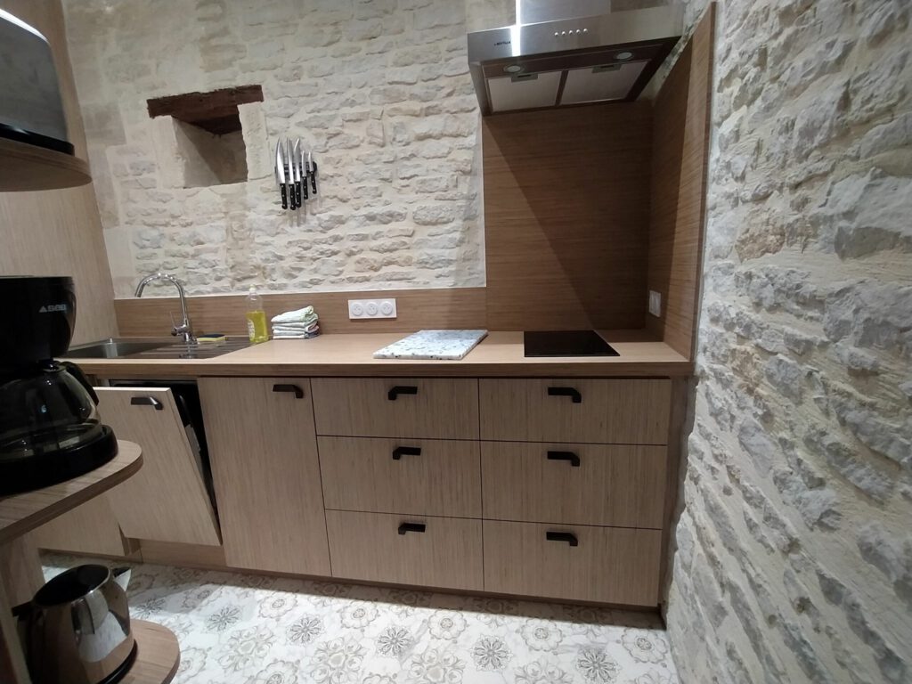 Moderna y elegante cocina en un junior después de Mathan Manor, con muros de piedra y equipos prácticos.