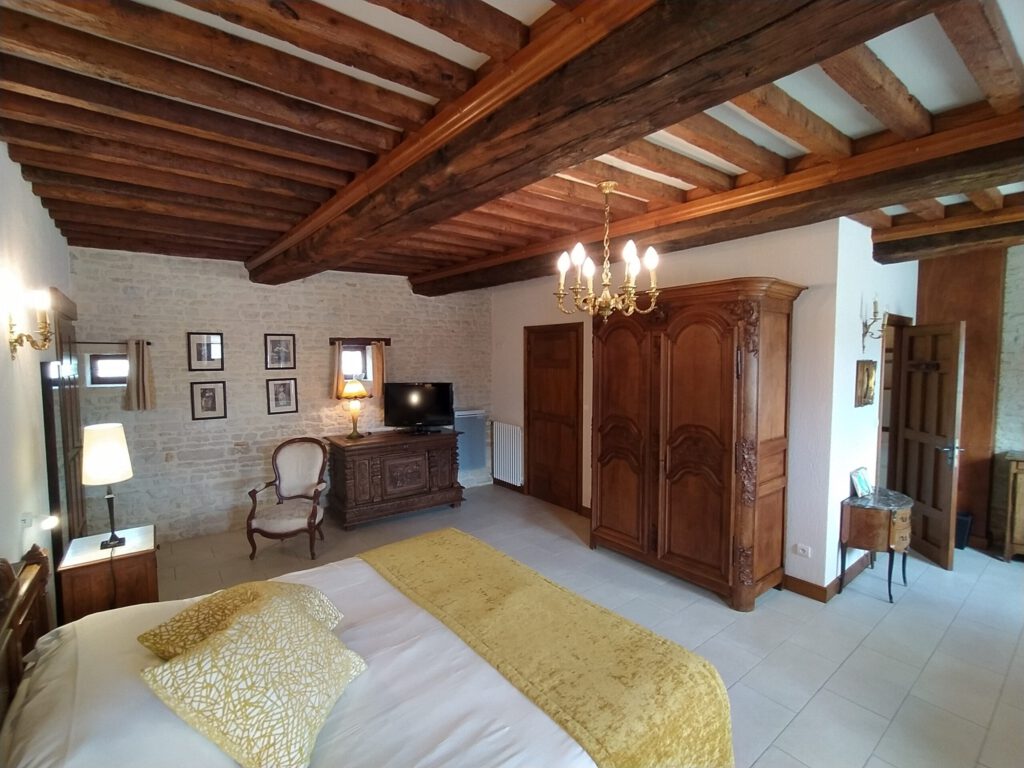 Junior Suite con Mathan Manor Kitchen, decoración elegante y cálida, ambiente tranquilo, paredes de piedra, techo con vigas expuestas.