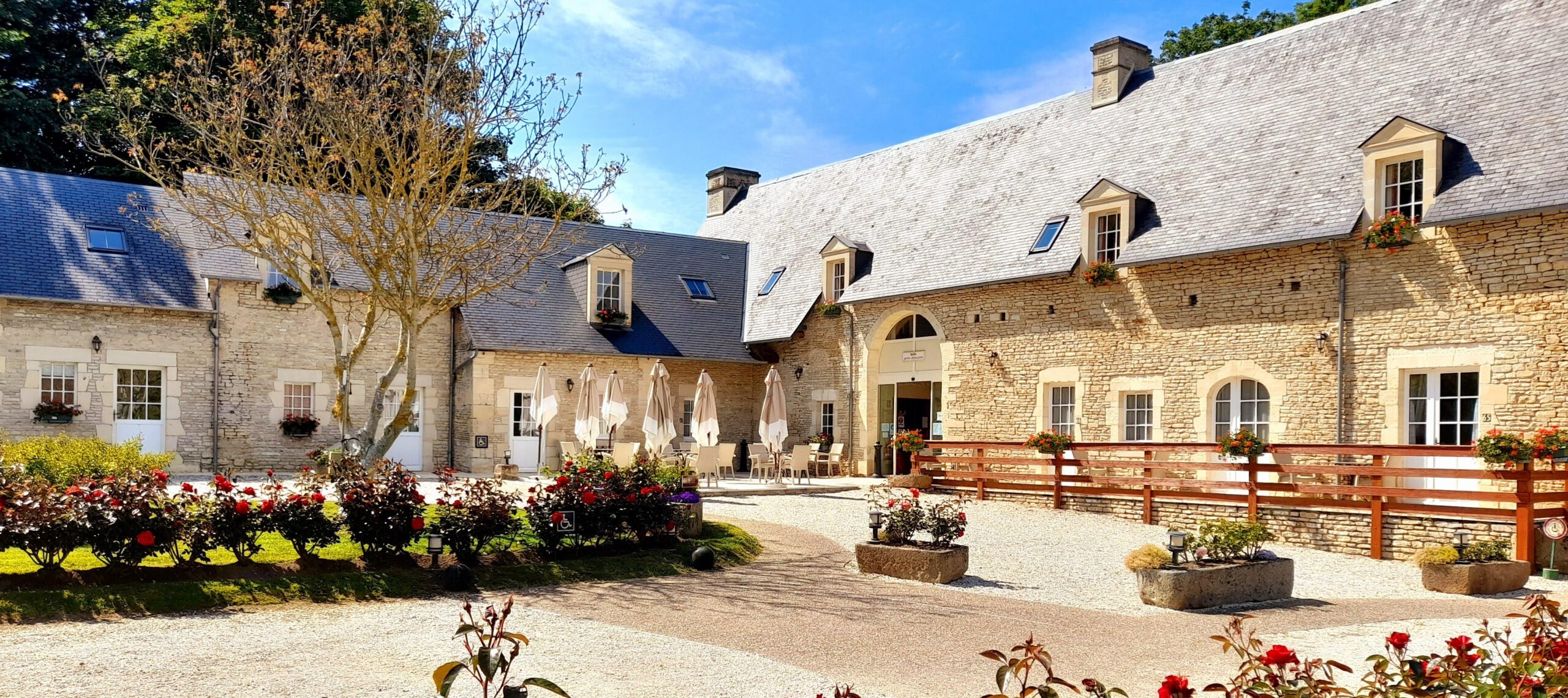 Blick auf das Mathan -Herrenhaus in Crépon mit seinen Steingebäuden, Terrassen und blumigen Gärten.