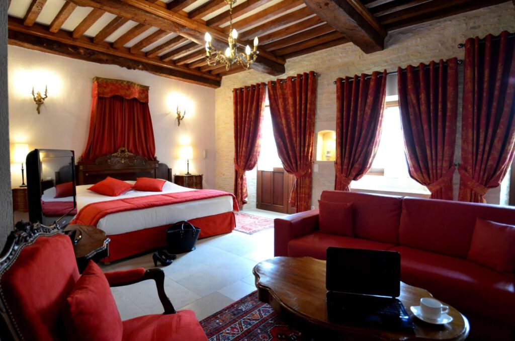 Elegant Mathan Manor Room, med dobbeltseng, røde lænestole og varm indretning.