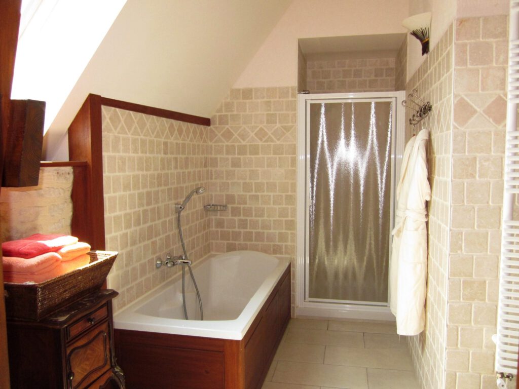 Baño brillante con bañera, ducha, toallas y bañeras, elegantemente decorado en un estilo contemporáneo.