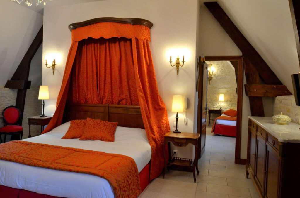 Suite familiar en el Mathan Manor con decoración elegante, cama cómoda y un ambiente cálido en un entorno histórico.