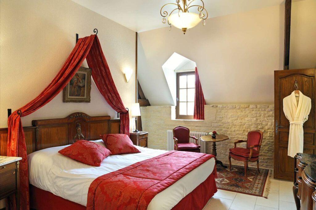 Habitación de la suite familiar en Mathan Manor, decoración elegante con camas, muebles vintage y un ambiente cálido.