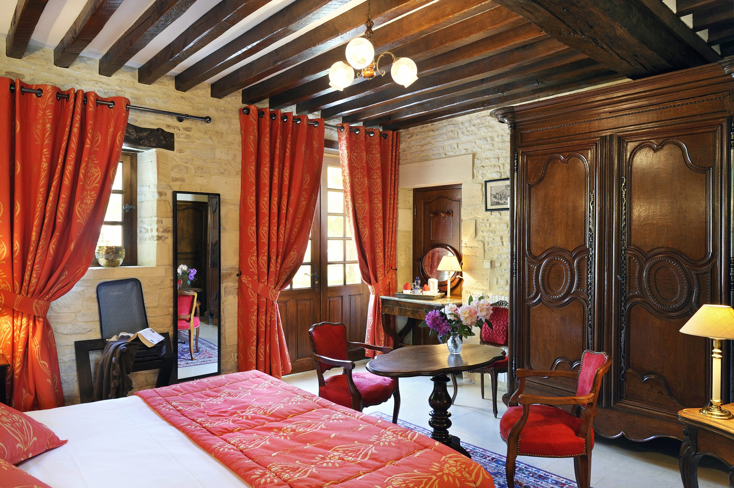 Mathan Manor Elegant Room, con cortinas rojas, muebles tradicionales y atmósfera cálida.