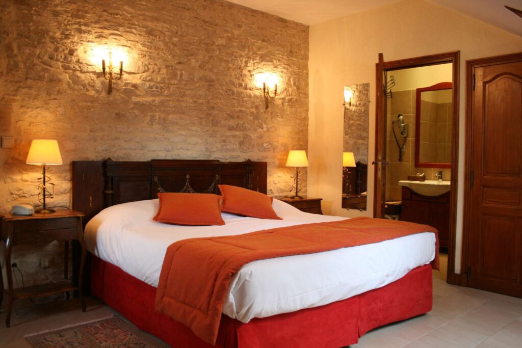 Elegante habitación Mathan Manor, con cama doble, decoración cálida y baño contiguo.