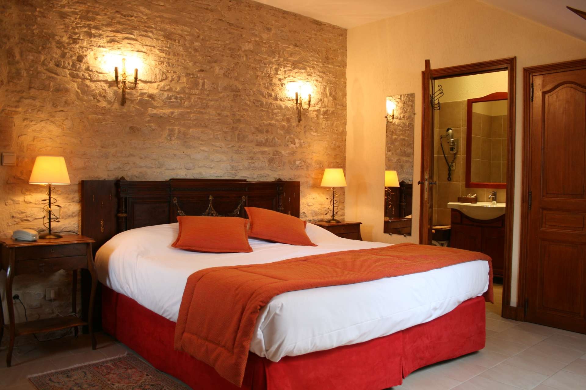Habitación cómoda en el Mathan Manor, que combina encanto histórico y equipos modernos, con muros de piedra y decoración elegante.